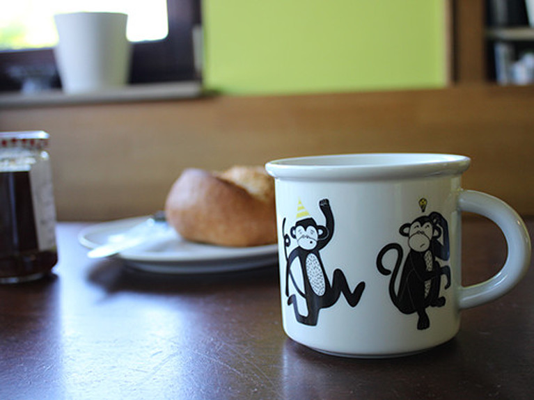 Die GMF-Tasse ohne Logo, aber dafür mit tanzenden Äffchen, auf dem Frühstückstisch.