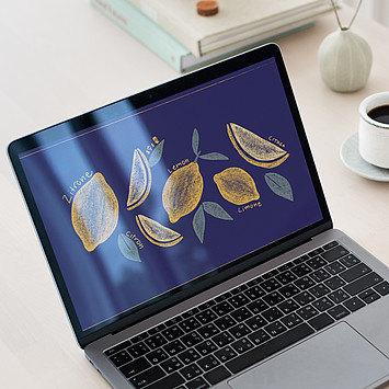 Auf einem aufgeklappten Laptop ist ein illustriertes Wallpaper mit Zitronen zu sehen.