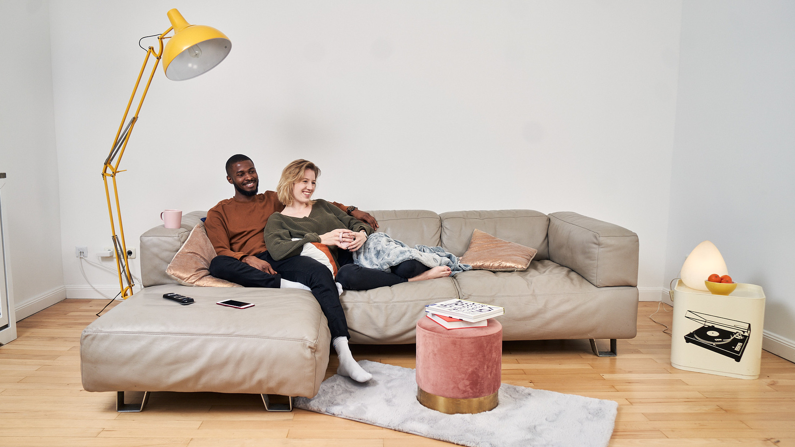 Ein junges attraktives Paar kuschelt gemeinsam auf einem Sofa.