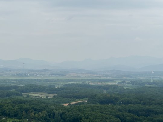 Blick auf Nordkoreas Propagandadorf und zwei Türme mit südkoreanischer und nordkoreanischer Flagge, die einander gegenüber stehen