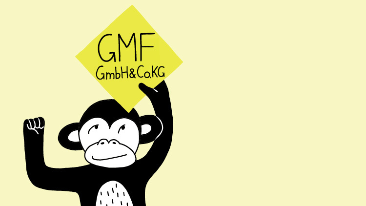 Äffchen hält Schild mit Schrift "GMF GmbH" hoch